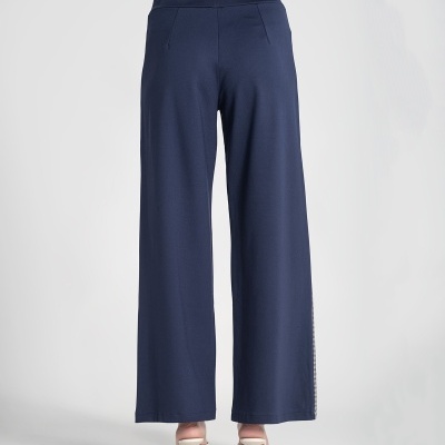 Calças largas azul-escuras vistas de trás com sapatos de salto