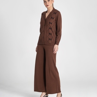 Conjunto feminino castanho de malha com casaco de botões e calças largas, sapatos pretos de salto médio.