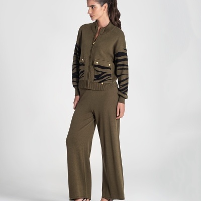 Mulher vestindo conjunto de malha castanha com padrão preto, calças largas e sapatos de salto pretos