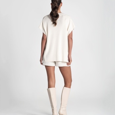 Conjunto feminino branco com blusa oversized, calções e botas altas de salto