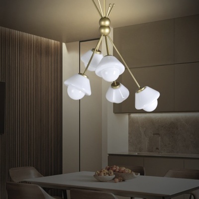 Candeeiro de teto dourado com abajures brancos sobre mesa branca e cadeiras de madeira clara numa sala de jantar moderna