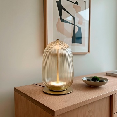 Candeeiro de mesa dourado em móvel de madeira com prato decorativo e quadro abstrato na parede