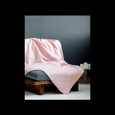 Manta rosa clara sobre sofá cinza com base de madeira