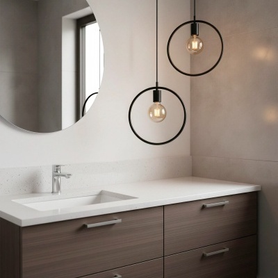 Móvel de casa de banho em madeira escura com tampos brancos, espelho redondo e lâmpadas pendentes na parede cinza