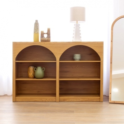 Estante de madeira com vasos cerâmicos e candeeiro sobre ela, espelho ao lado