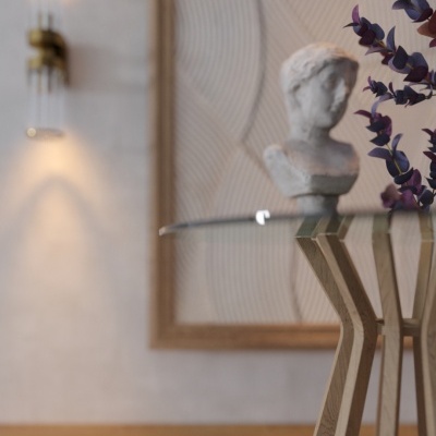 Mesa de vidro com base em madeira clara e decoração incluindo busto e folhas roxas