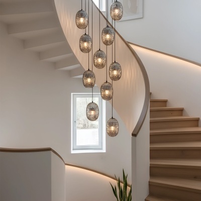 Candeeiros pendentes metálicos cinzentos iluminados na escada em madeira clara e parede branca