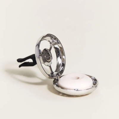 Difusor automóvel cromado aberto com almofada branca, clipe preto, fundo claro