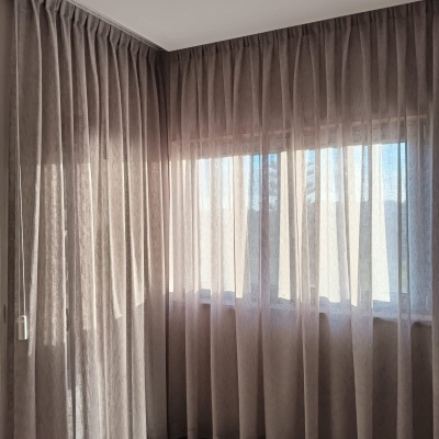 Cortinas translúcidas bege claro em janela de quarto