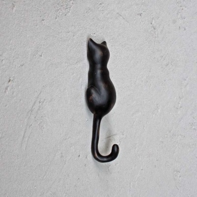 Gancho de parede preto em forma de gato num fundo cinzento