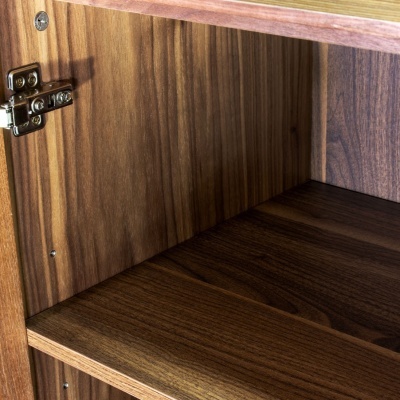 Interior de móvel de madeira escura com prateleiras e dobradiça metálica