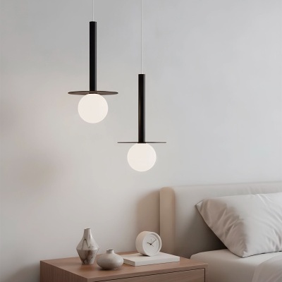 Mesa de cabeceira de madeira clara com vasos de cerâmica, relógio branco, cama branca e duas luminárias pendentes negras com globos de luz brancos.