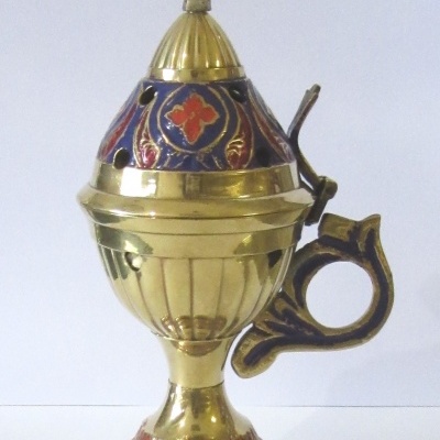 Incensário dourado com decoração colorida e cruz no topo