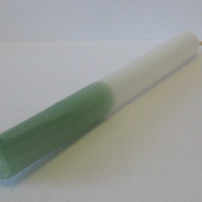 Vela bicolor verde e branca em superfície branca