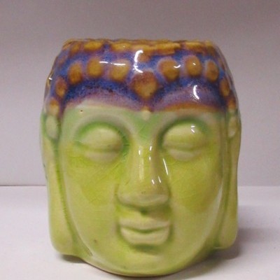 Vaso cerâmico verde em forma de cabeça de Buda com detalhes azuis e castanhos