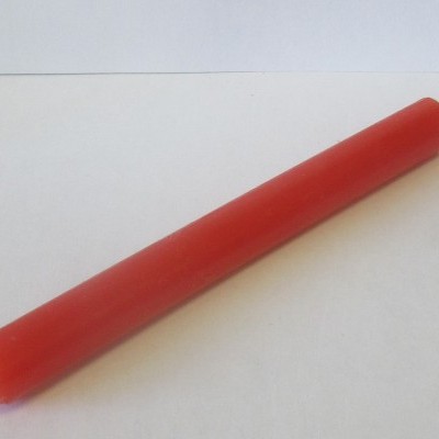 Vela vermelha lisa com pavio sobre fundo branco