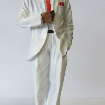 Estátua decorativa de homem com fato branco e acessórios vermelhos