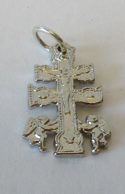 Pendente prateado em forma de cruz com figura de Cristo e dois anjos.