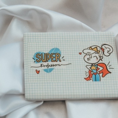 Caixa decorada com desenho e texto 'SUPER professora' sobre tecido branco