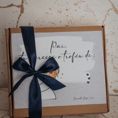 Caixa de presente com fita azul e cartão com texto em português