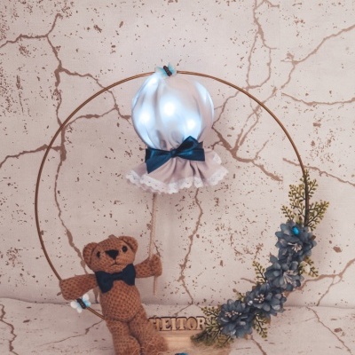 anel decorativo com balão branco, urso de crochê e flores azul-esverdeadas