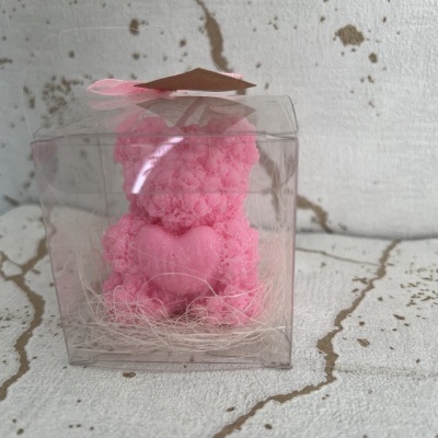 Urso rosa felpudo com coração numa caixa de plástico transparente