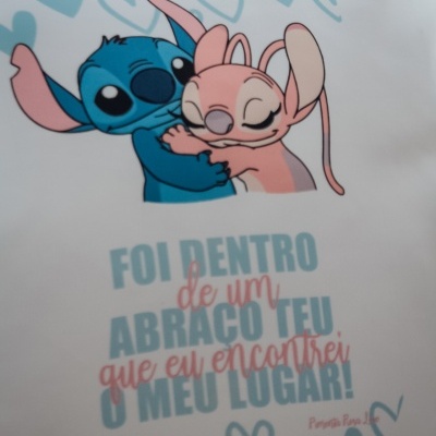 Almofada branca com personagens cartunescas a abraçarem-se e texto em português.