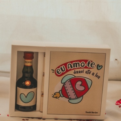 Garrafinha com coração azul e caixa com ilustração de foguete e texto 'eu Amo-te daqui até à lua'
