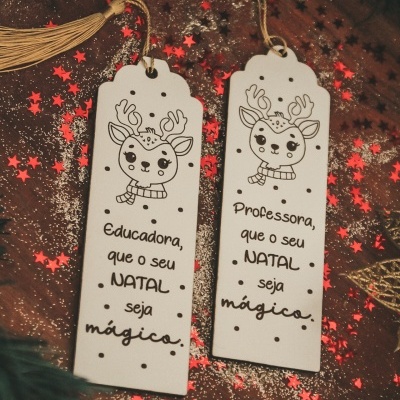 Dois marcadores de livros de madeira branca com desenho de rena e textos em português com tema de Natal