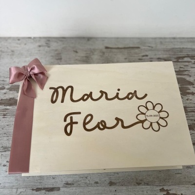 Caixa de madeira clara com inscrição e fita rosa