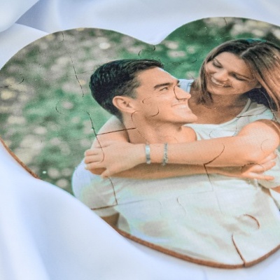 Quebra-cabeça em forma de coração com foto de casal jovem sorridente.
