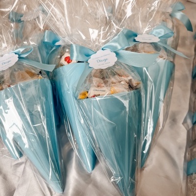 Cones de presente azuis embalados em celofane com fita azul e etiquetas brancas