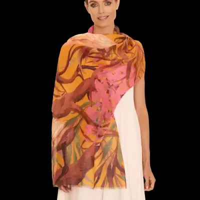 Lenço colorido com padrão abstrato de folhas e galhos, usado por mulher com vestido branco