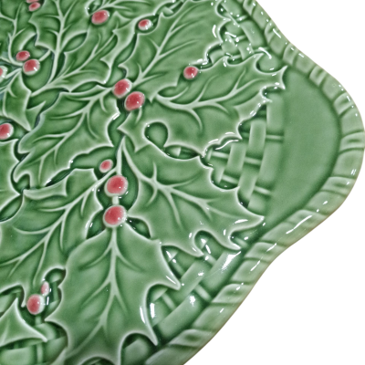 Prato cerâmico verde com padrão de folhas de azevinho em relevo e frutos vermelhos