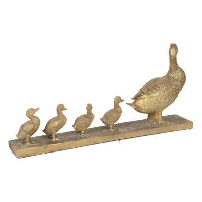 Escultura dourada de pato com quatro patinhos numa base retangular