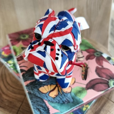 Boneco de bulldog em tecido com padrão da bandeira do Reino Unido sobre caixas com padrões florais