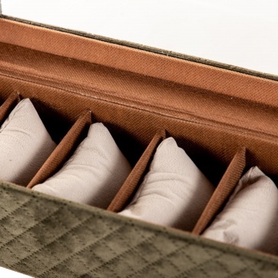 Caixa organizadora verde acolchoada com seis almofadas bege para relógios