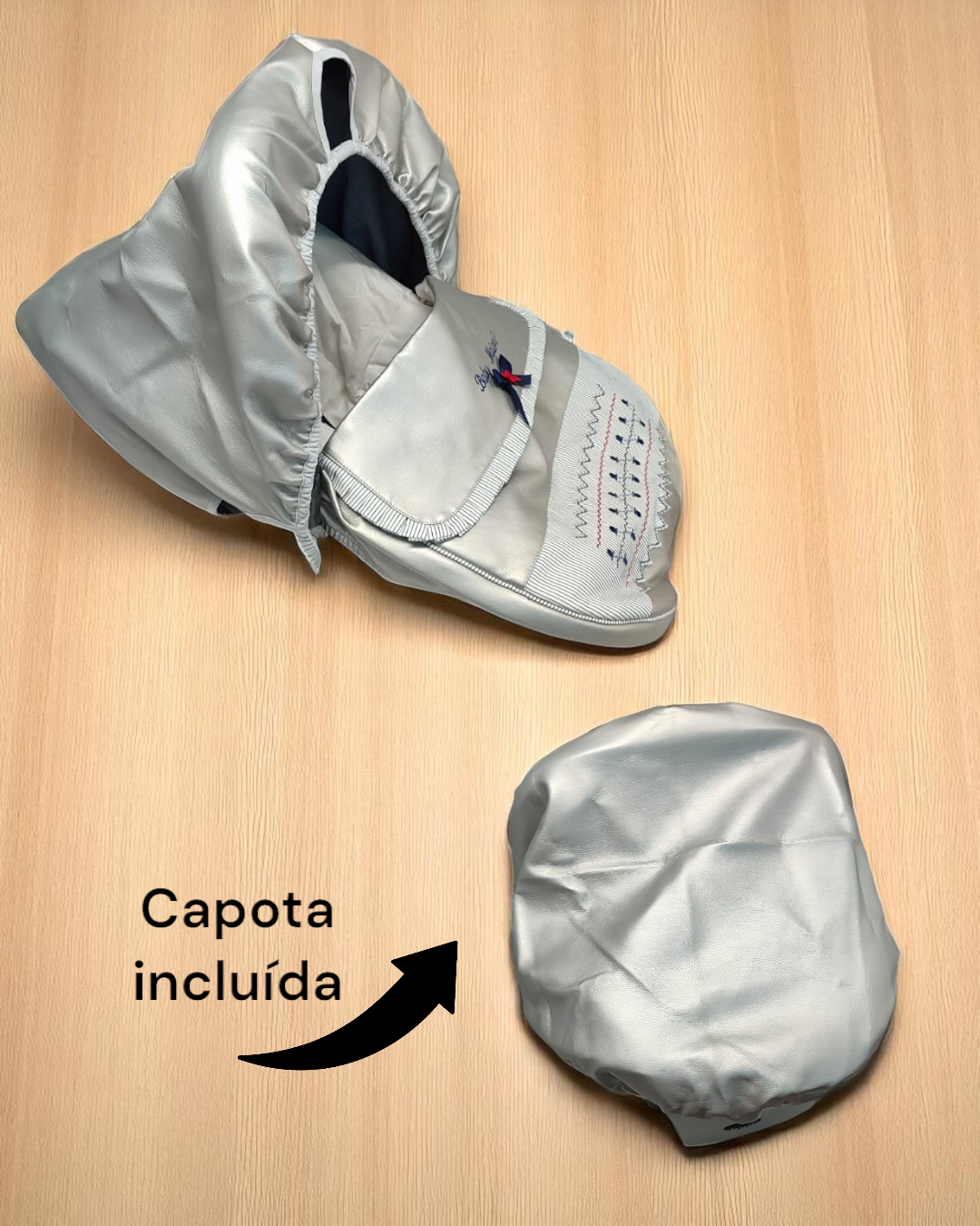 Carrinho de bebé cinza com capota de tecido prateado e texto Capota incluída