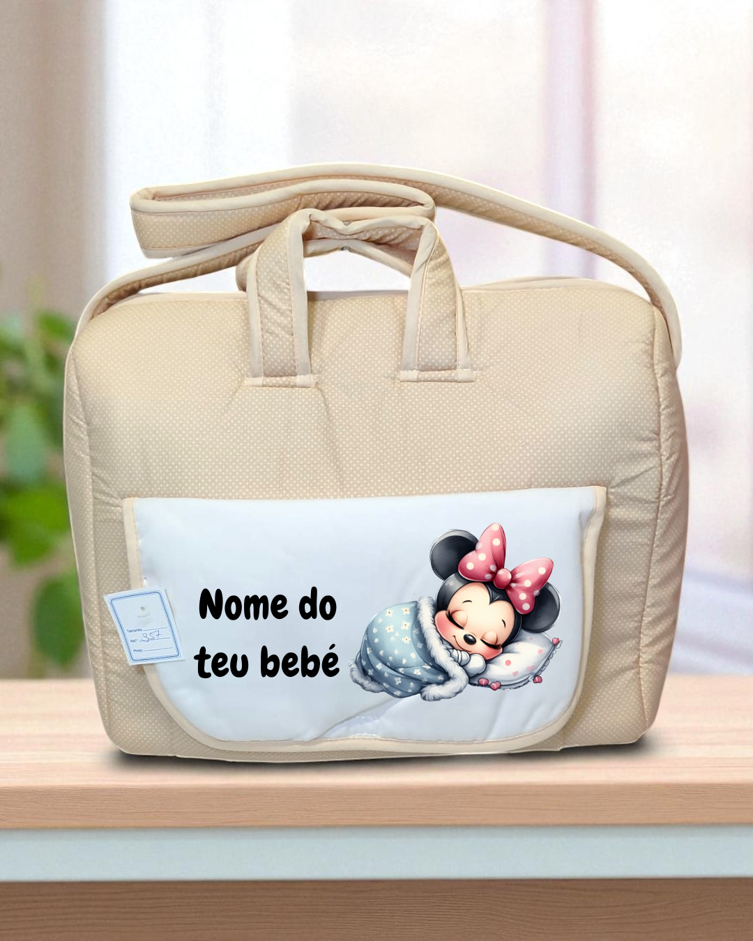 Mala de bebê bege com bolso branco e personagem Minnie adormecida