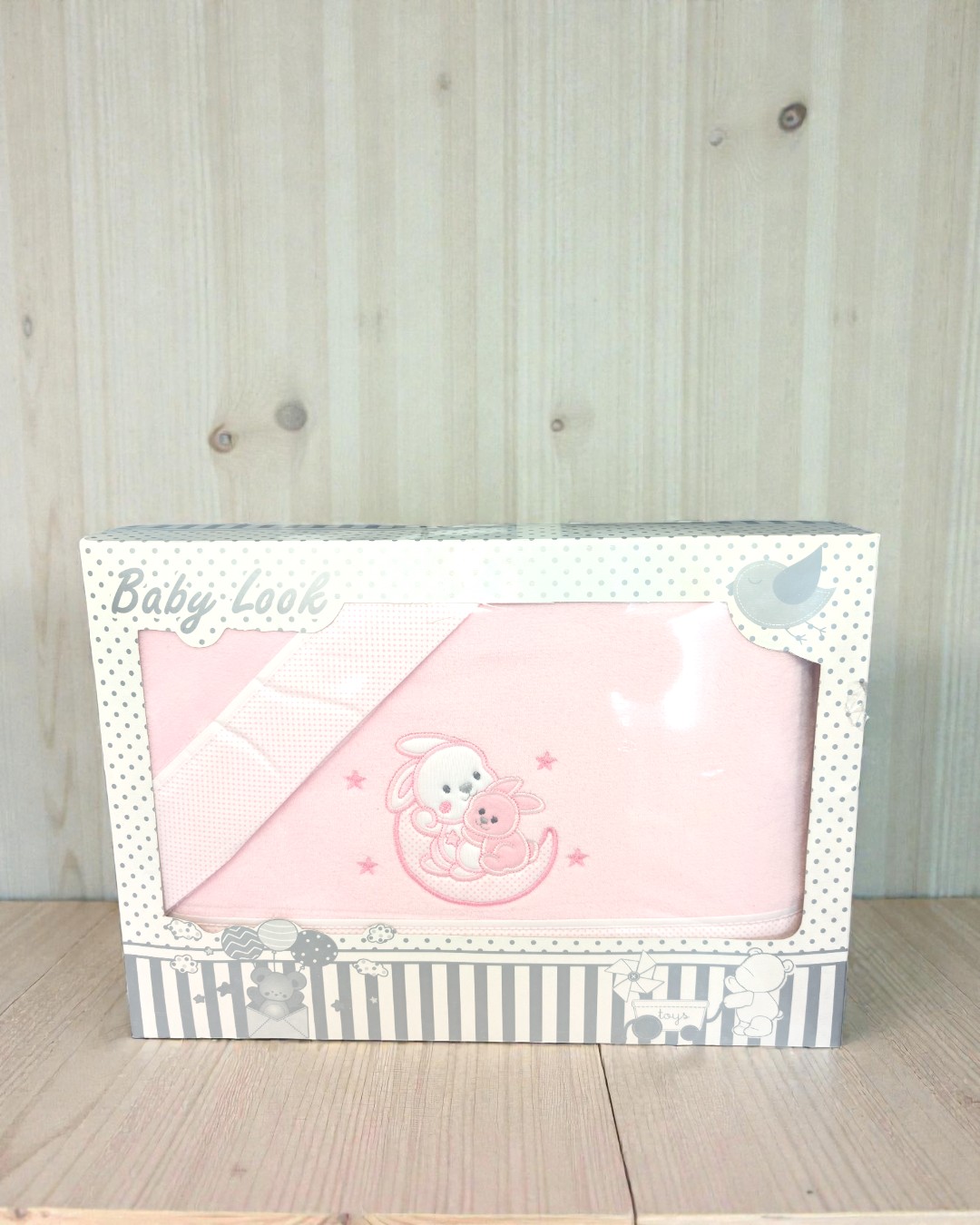 Manta rosa para bebé com bordado de coelhinhos numa caixa decorada