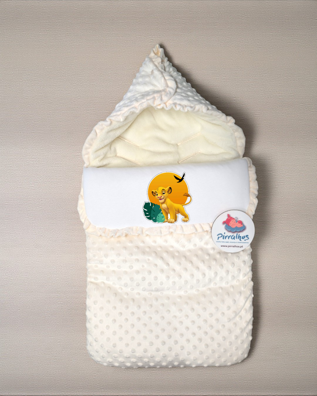 Saco de bebé bege com estampa do personagem Simba do Rei Leão e etiqueta Pirralhos.