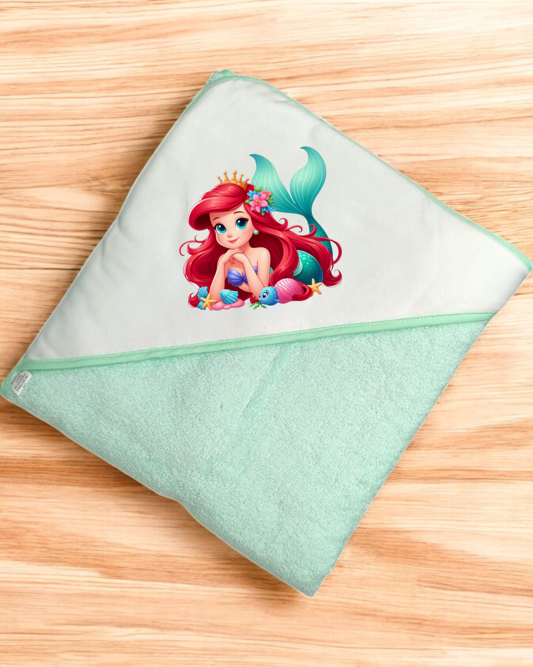 Toalha de banho de bebé verde claro com capuz branco e imagem colorida de sereia.