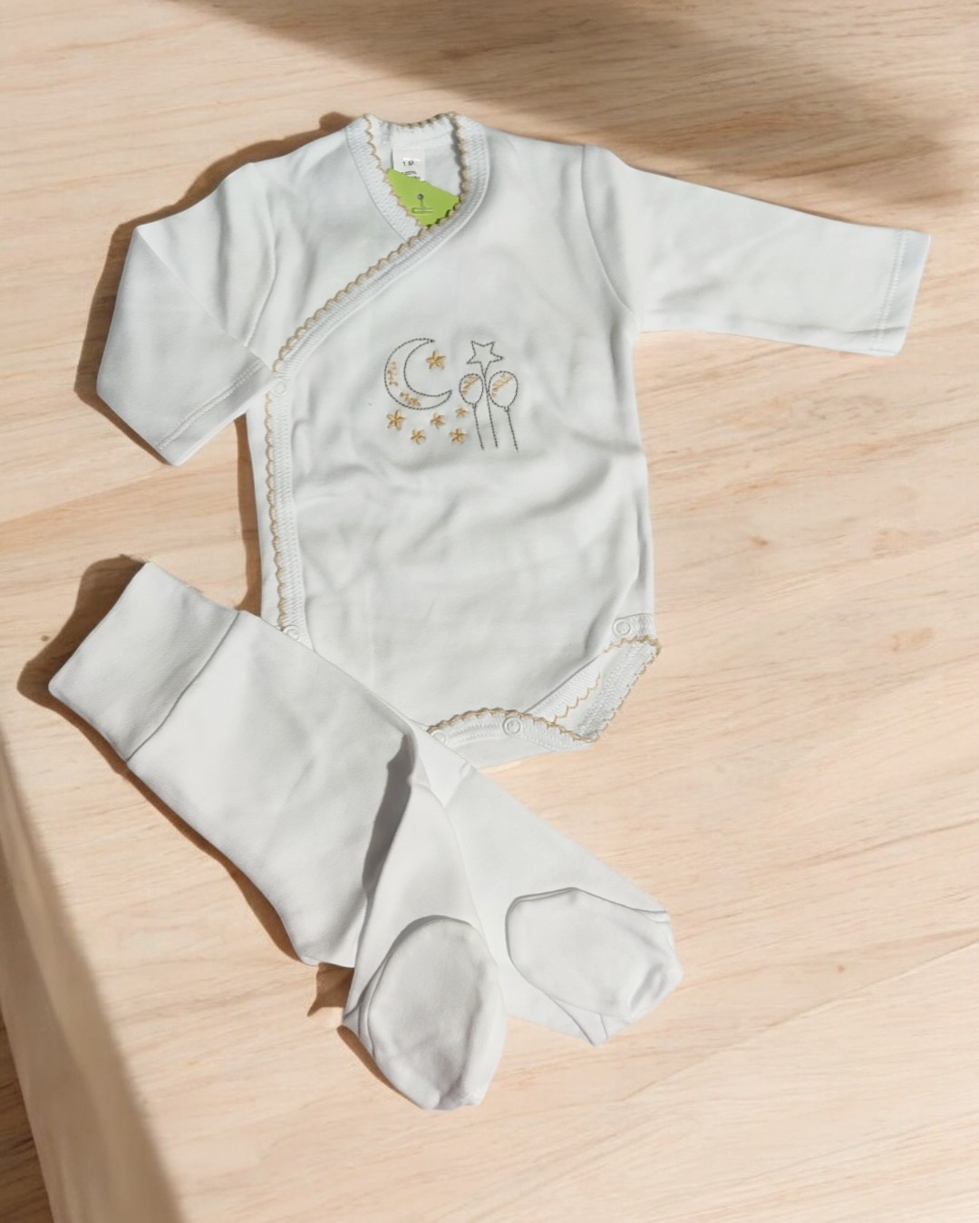 Conjunto de roupa de bebé branco com bordado e calças com pés fechados