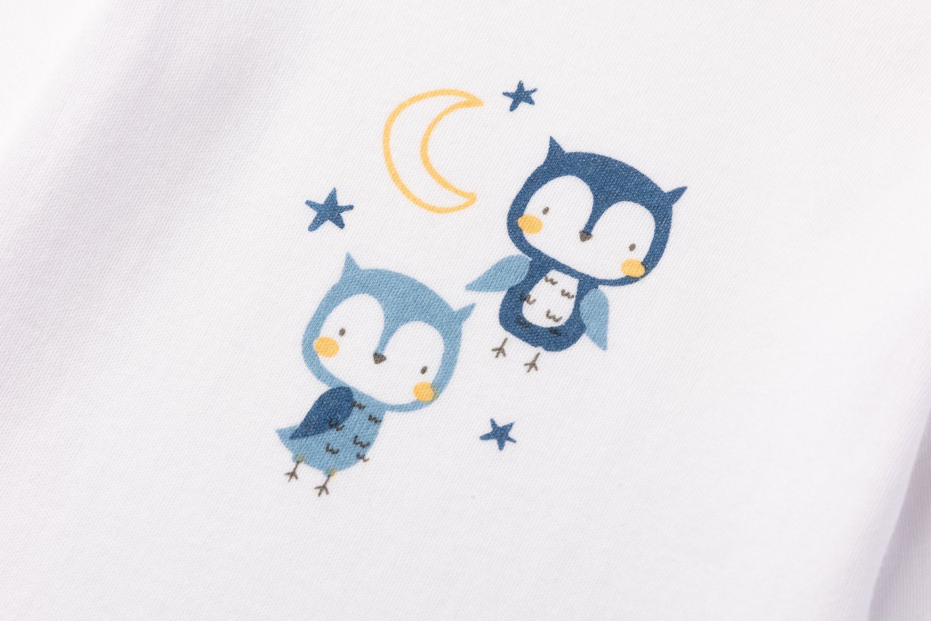 Estampa com duas corujas, estrelas e lua em tecido branco