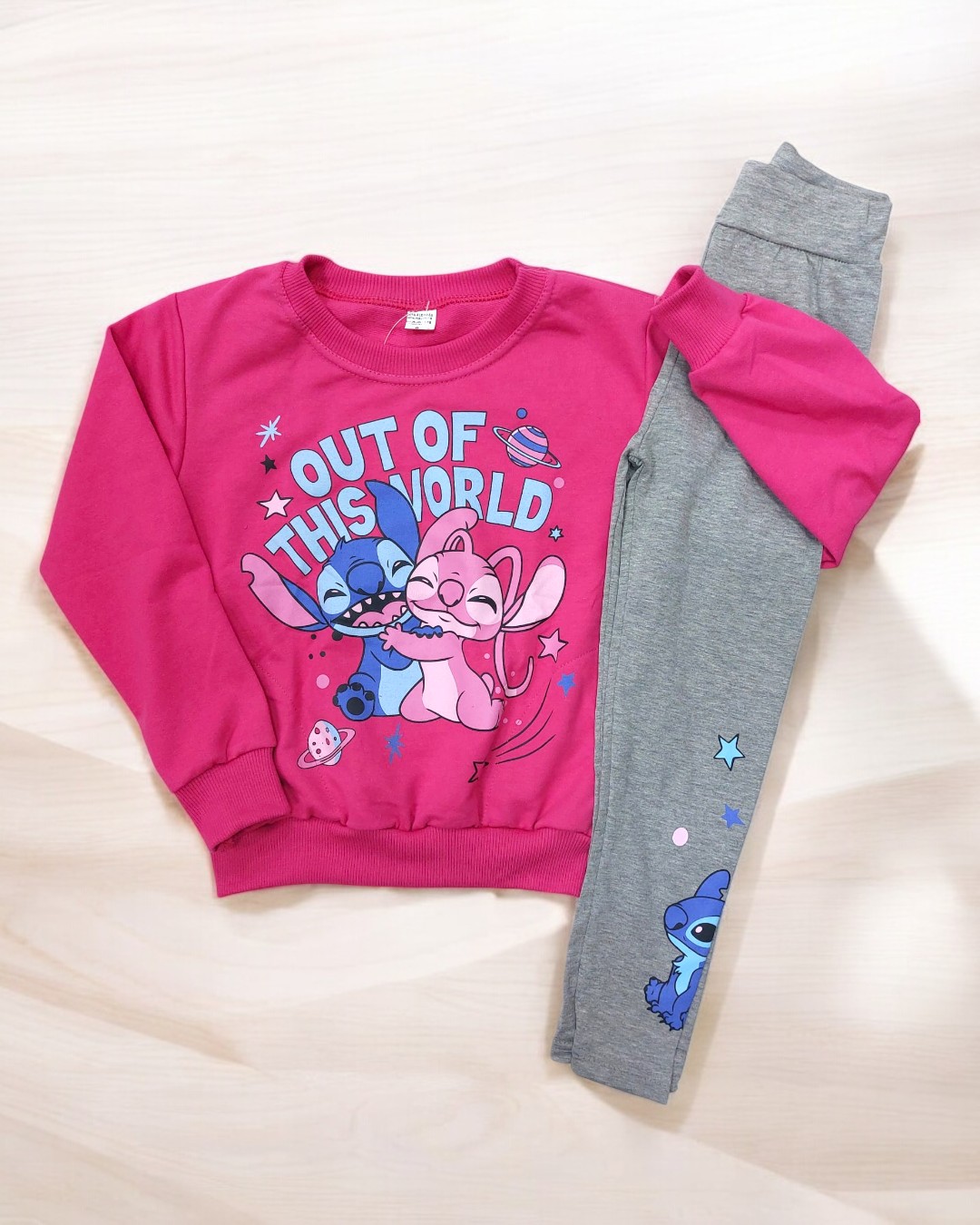 Conjunto infantil rosa e cinza com estampa colorida e personagens.