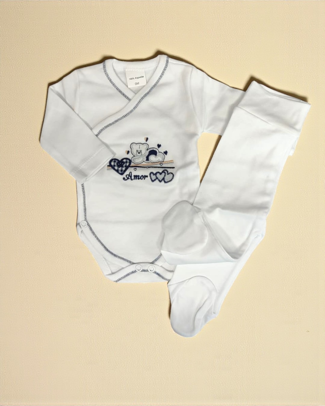 Conjunto de bebé branco em algodão com body e calças com pezinhos, com estampado de ursinho e corações.