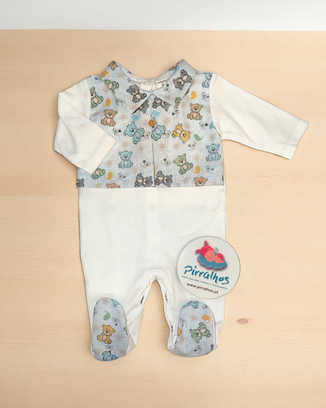 Macacão de bebé creme com padrão de ursinhos coloridos na parte superior e pés, etiqueta Pirralhos