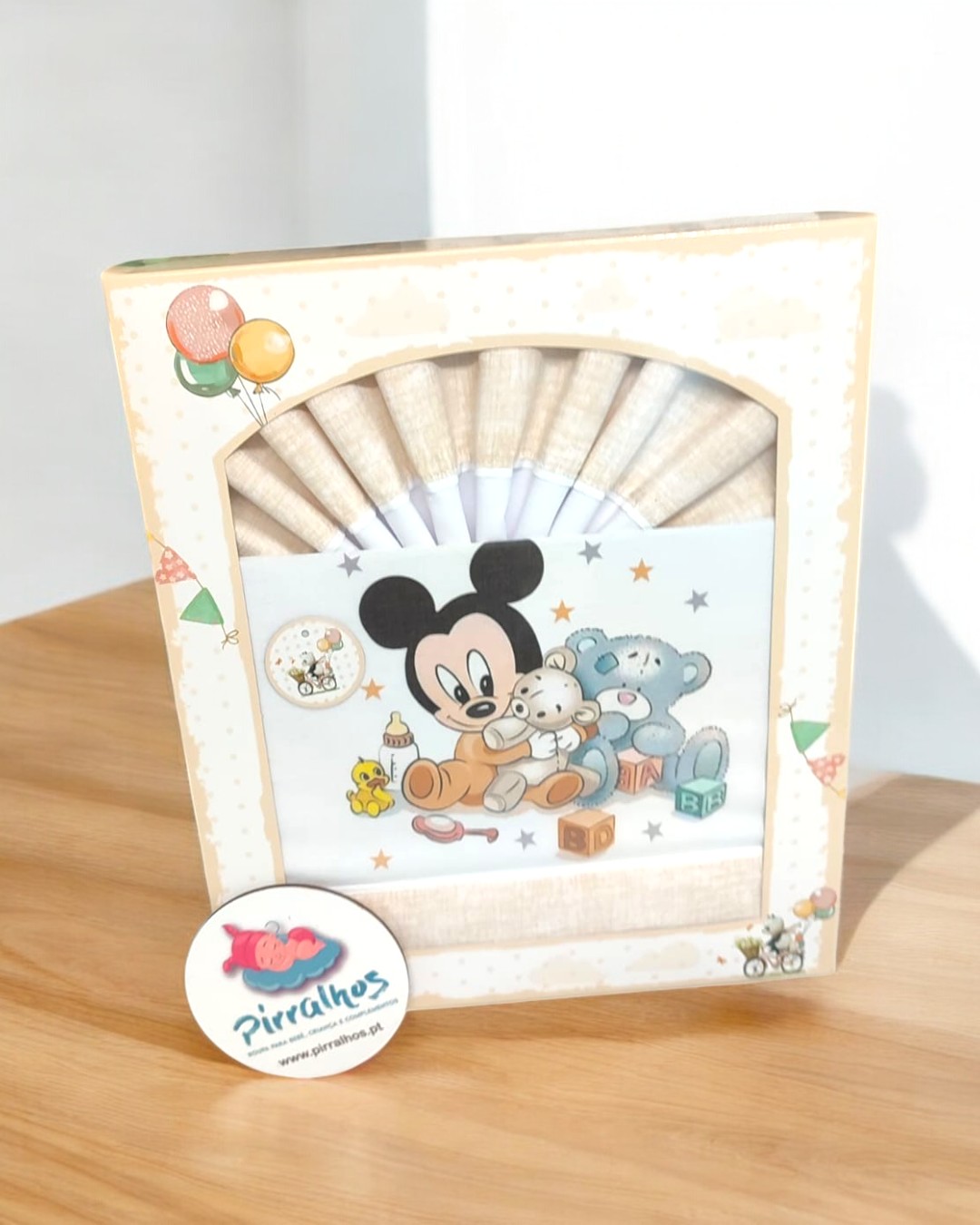 Travesseiro com desenho animado de um rato e ursos em embalagem creme com balões.