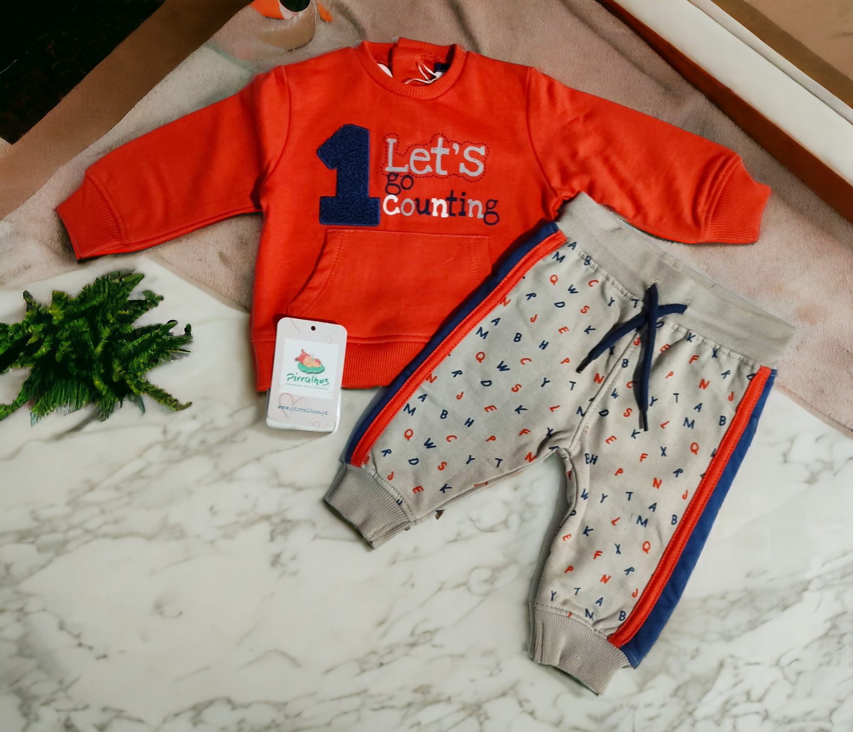 Conjunto infantil camisola laranja e calças cinzentas com padrão de letras coloridas