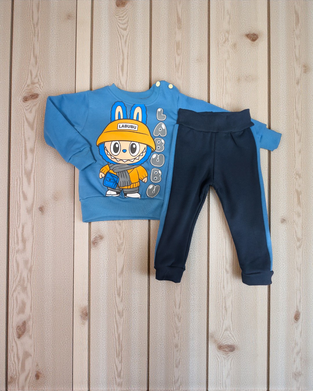 Conjunto de roupa de criança azul com estampa de personagem e calças azul-escuras